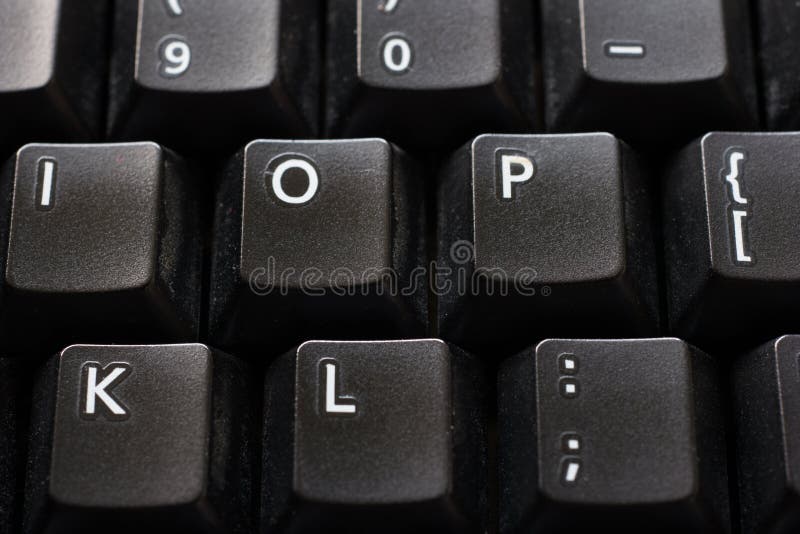 Black plastic standard English computer keyboard close up macro shot top side view.