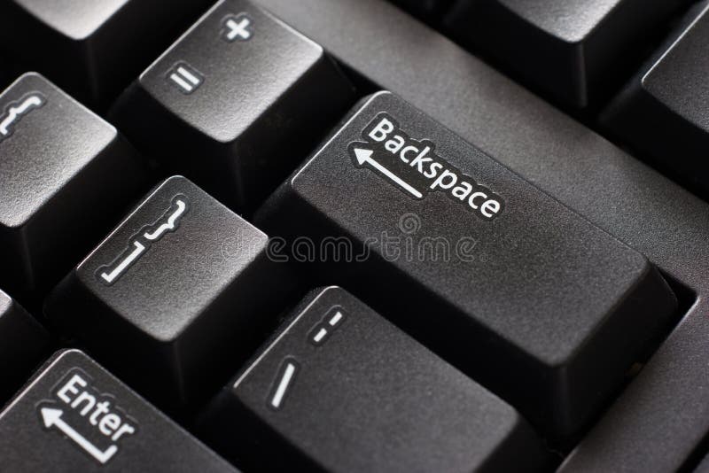 Black plastic standard English computer keyboard close up macro shot top side view backspace button.