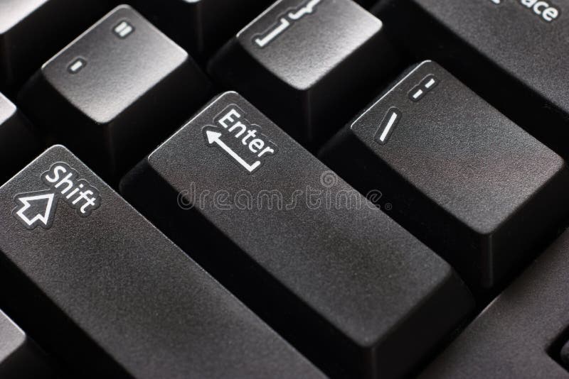 Black plastic standard English computer keyboard close up macro shot top side view Enter button.