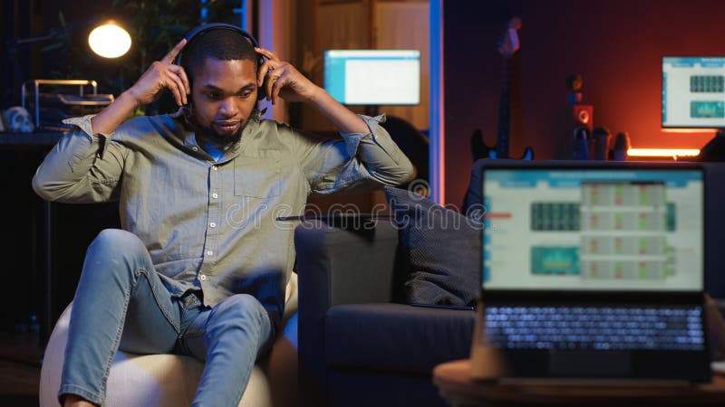 Black remote worker navigating on tablet next to screen running analytics royalty free stock photo