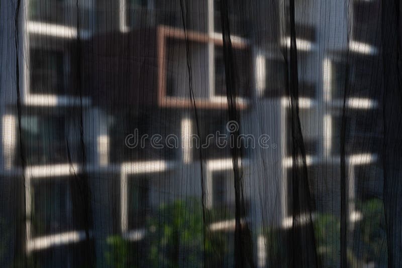 Black see through curtains with blurred building background through window frame. Selective focus on black see through curtains royalty free stock photos Black see through curtains with blurred building background through window frame. Selective focus on black see through curtains royalty free stock photos