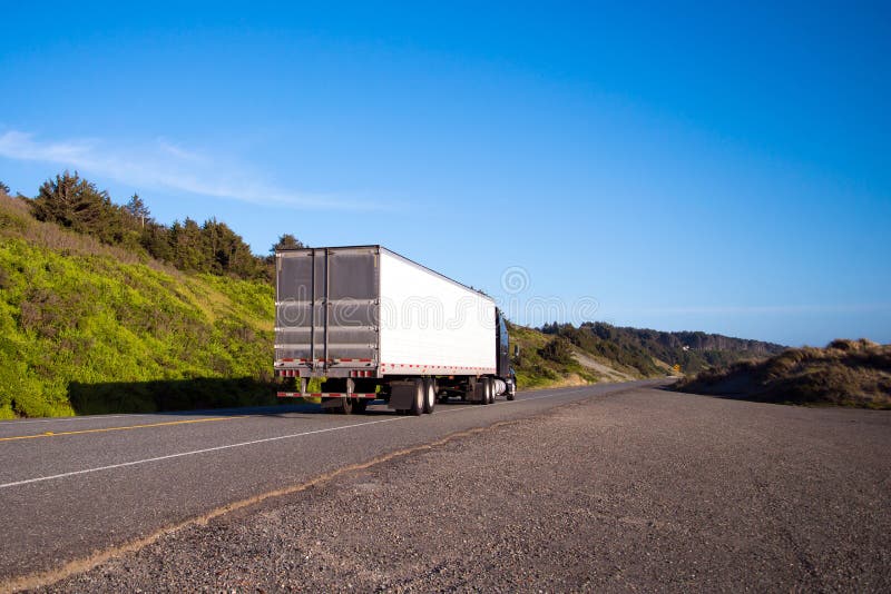 Black semi truck with trailer drive on straight road with green royalty free stock photo Black semi truck with trailer drive on straight road with green royalty free stock photo