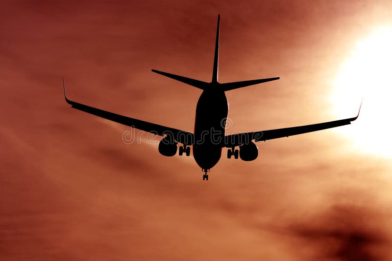 Black silhouette of airplane against the sun