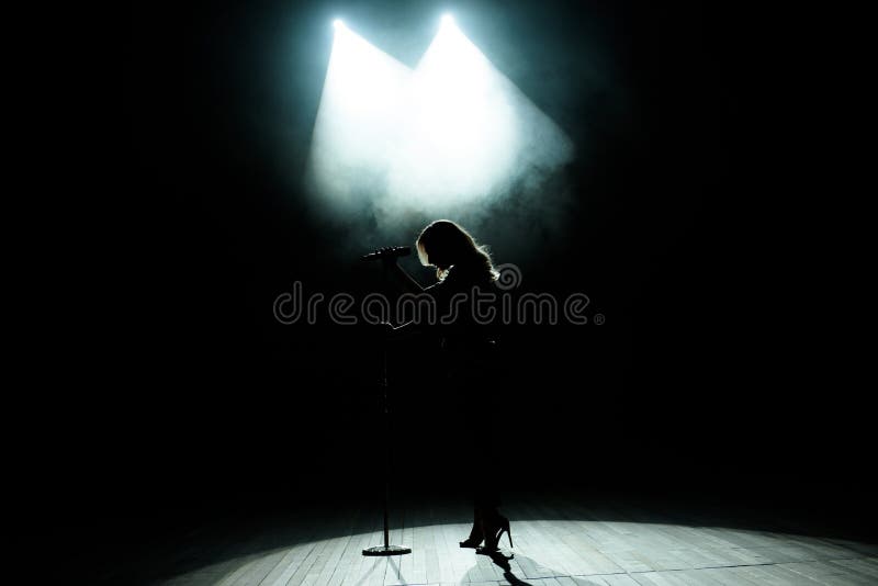 Black Silhouette of Female Singer with White Spotlights in the ...