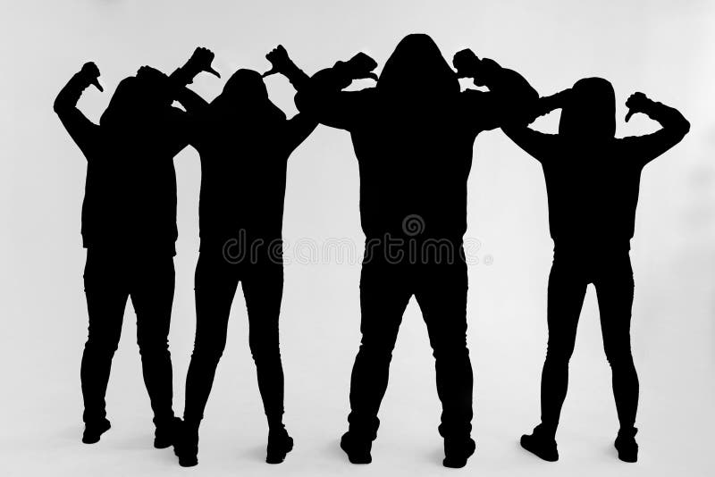 Black silhouette group people isolated on a white background. Three women and one man standing with their backs to the viewer raised their hands and pointed their fingers at the back