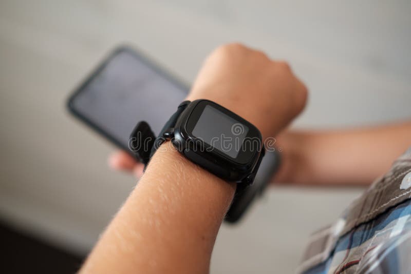 black smart watch on the boy`s hand