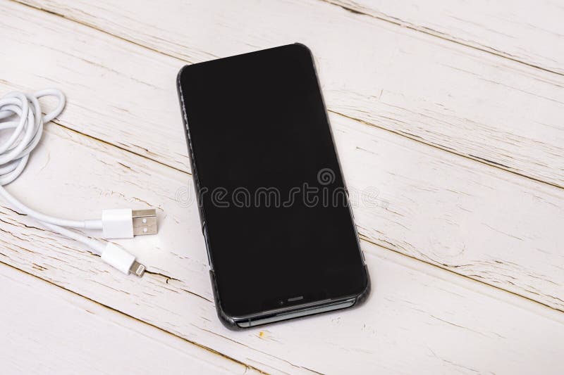 A Black Smartphone Stuck with White Charging Cable Stock Photo Image