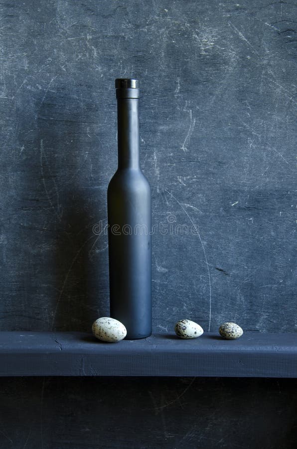 Black still-life with bottle and bird eggs
