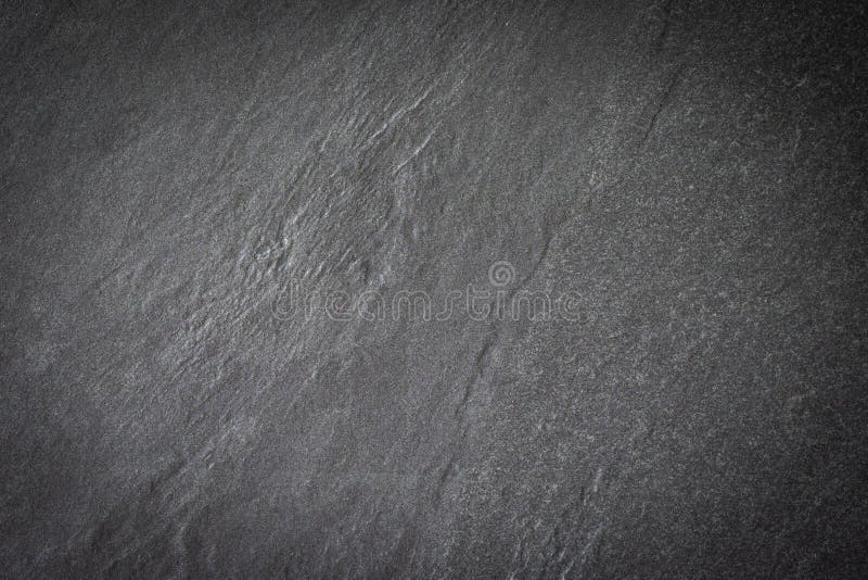 Black stone slate background. Natural hard rock dark grey texture. Abstract surface rough pattern with darkness and vignet. Blank