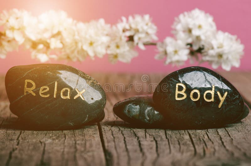 Black Stone Treatment on a Wooden Table. Spa and Wellness Concept