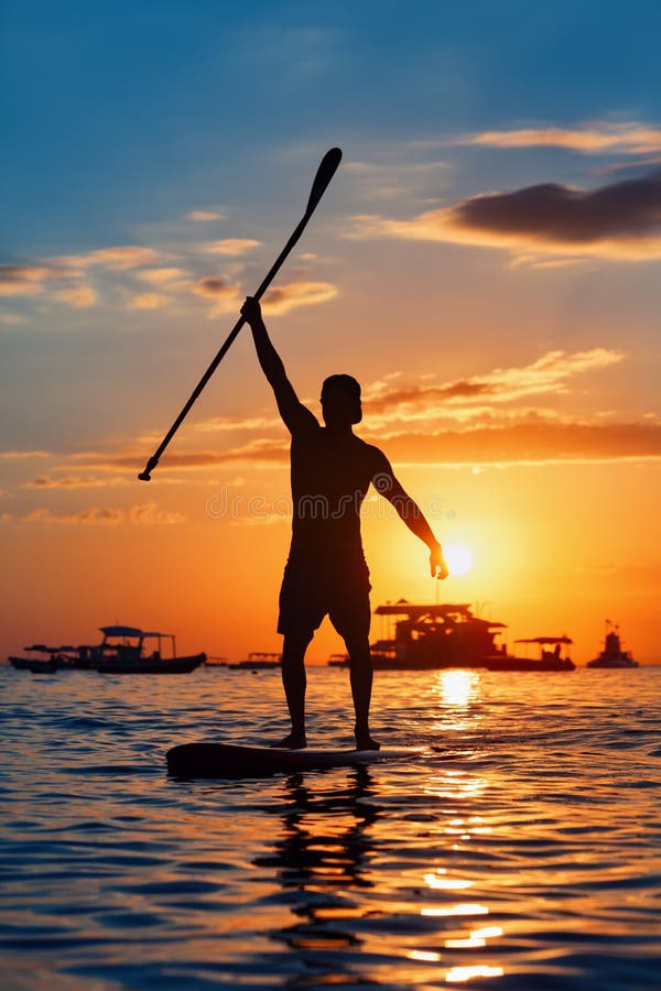 Black Sunset Silhouette of Paddle Boarder Standing on SUP Stock Image ...