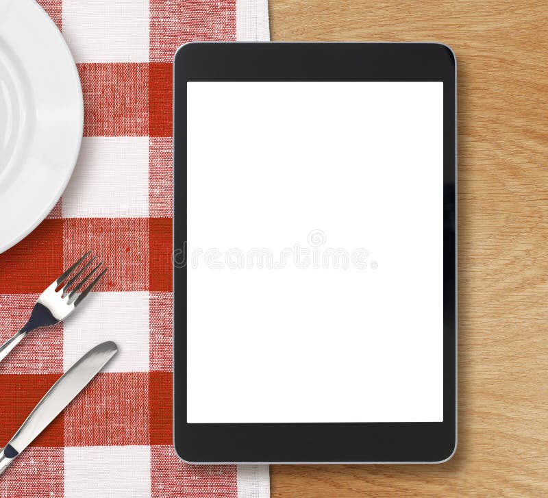 Black tablet pc on dinner table with blank screen stock image Black tablet pc on dinner table with blank screen stock image