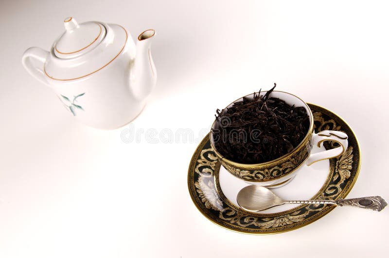 Black tea in cup with pot