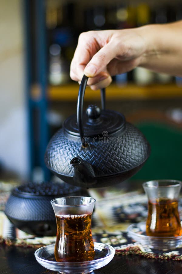 Black Tea and Teapot in Hand, Turkish Tea Glasses, and Old Iron Teapot