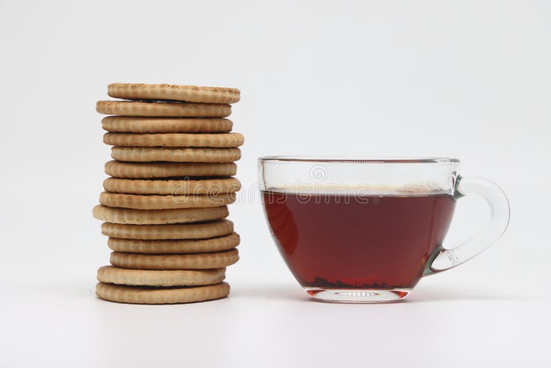Black Tea in a Transparent Glass Bowl and a Tall Stack of Cookies Stock