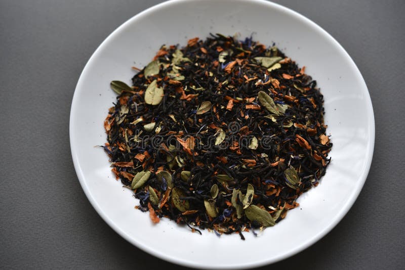Black Tea on a White Plate. Dry Tea with Spices for Brewing Stock Image