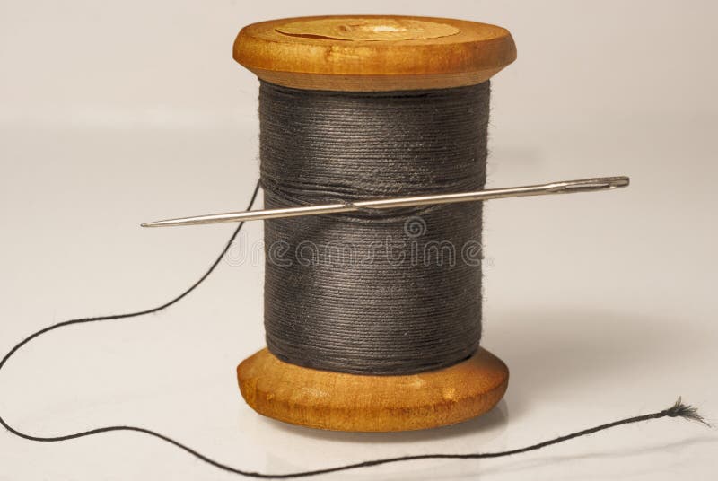 Black Thread with a Needle on an Ancient Antique Old Wooden Coil