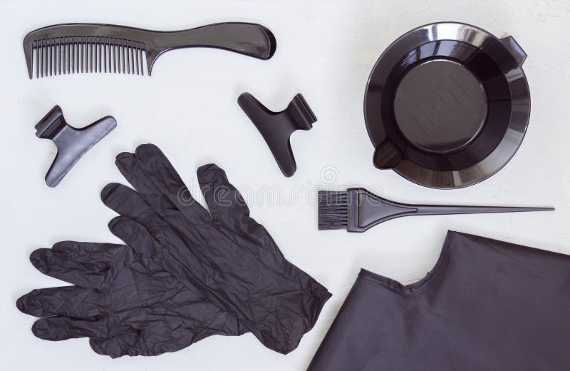 Black tools for hair coloring. Comb, bowl, brush, gloves, hair clips and Cape. Hair salon accessories