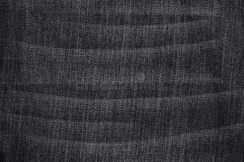 Black used jeans with folds in white royalty free stock images