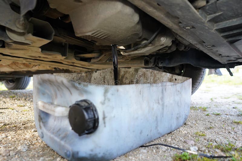 Black used oil drained from the car\'s engine. Draining old car oil. Oil changing in the car. Car oil change. royalty free stock photo