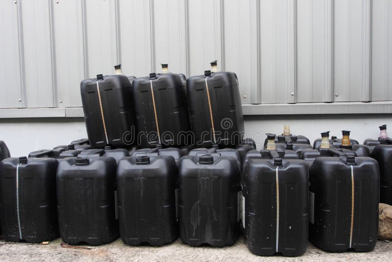 Black used oil gallons pile royalty free stock photos