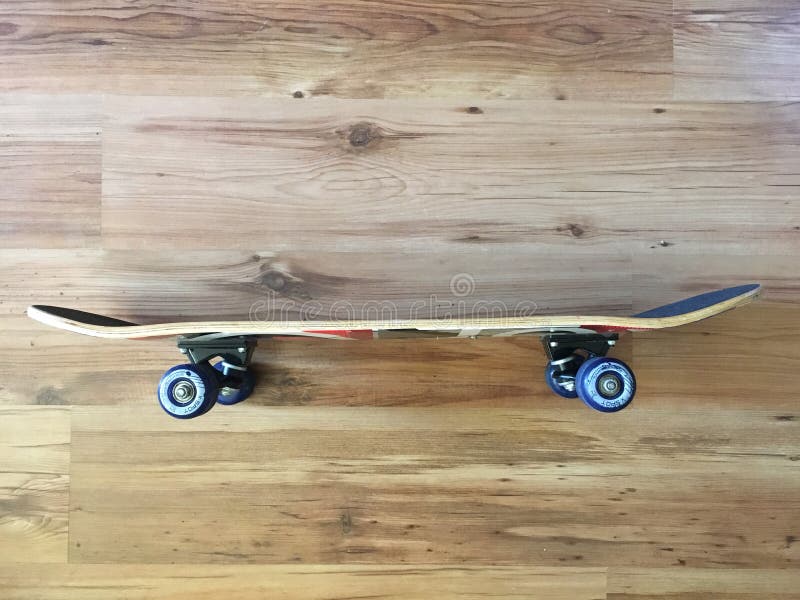 Black used skateboard on a light wooden background. royalty free stock photography