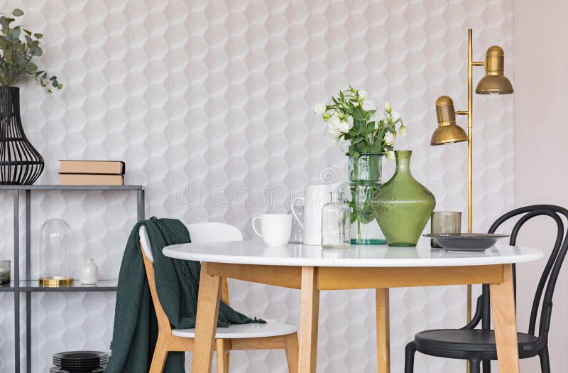 Black and white chair at wooden table in dining room interior with flowers and gold lamp. Real photo stock illustration Black and white chair at wooden table in dining room interior with flowers and gold lamp. Real photo stock illustration