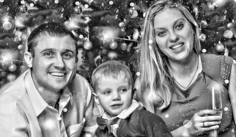 Black and white.Happy young family meet the new year with their young son near the Christmas tree. stock photo Black and white.Happy young family meet the new year with their young son near the Christmas tree. stock photo