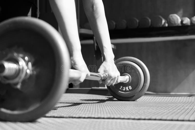 Black and white image of women hand lifting the steel dumbbell in a gym muscle building stock photos Black and white image of women hand lifting the steel dumbbell in a gym muscle building stock photos