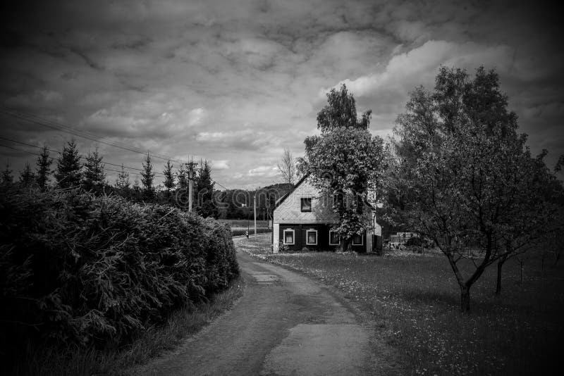 Black-and-white nostalgia of a village with a cottage, with a shrubby fence and a touch of classic village well-being and mood. Black-and-white nostalgia of a village with a cottage, with a shrubby fence and a touch of classic village well-being and mood.