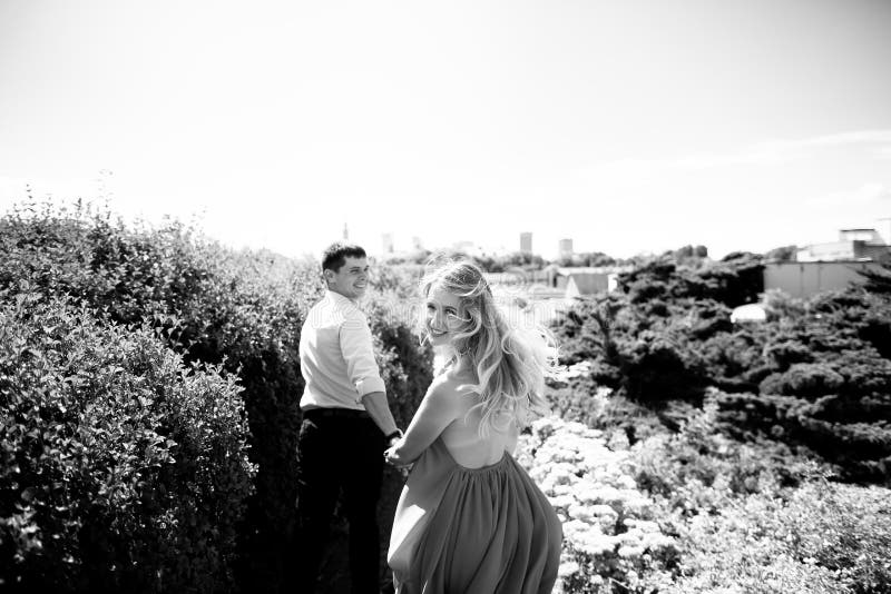 Black and White Photo from the Back. a Man Leads His Woman by the Hand ...