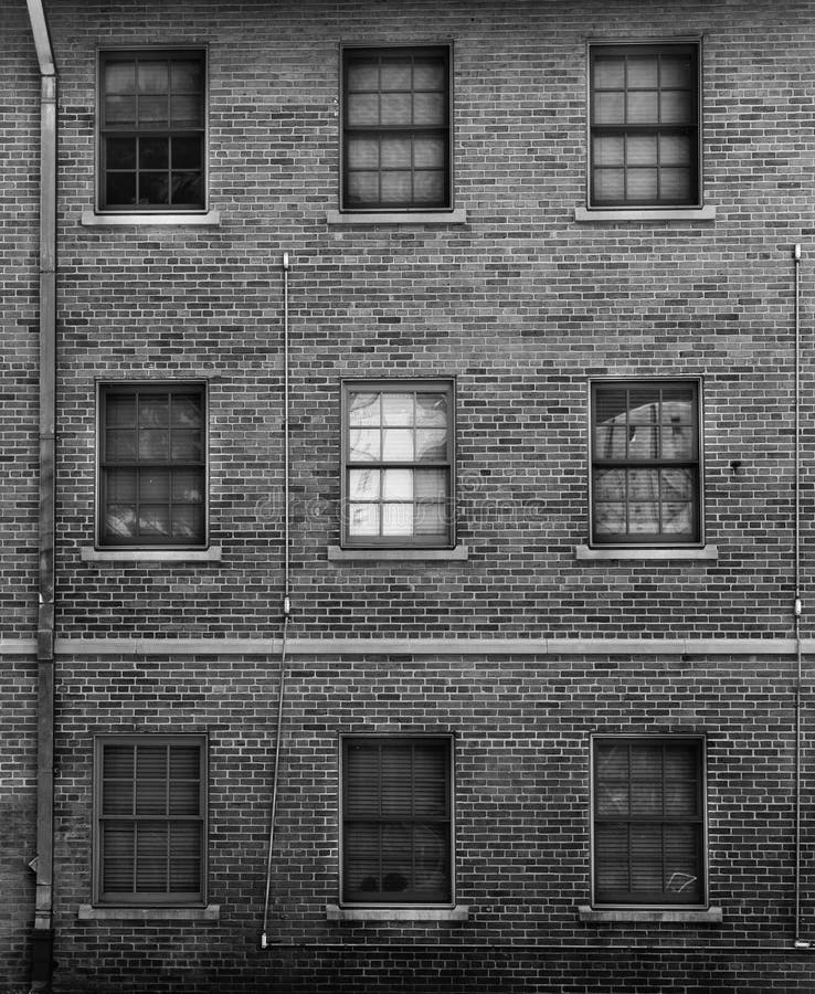 Black and white photo of brick facade with windows