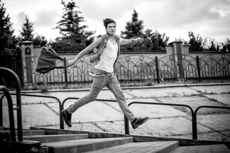 Black-and-white photo of a guy with a bag of fashion, running up