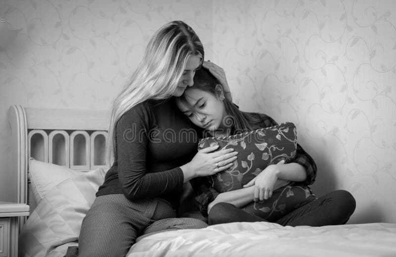 Black and white portrait of mother consoling teenage daughter on