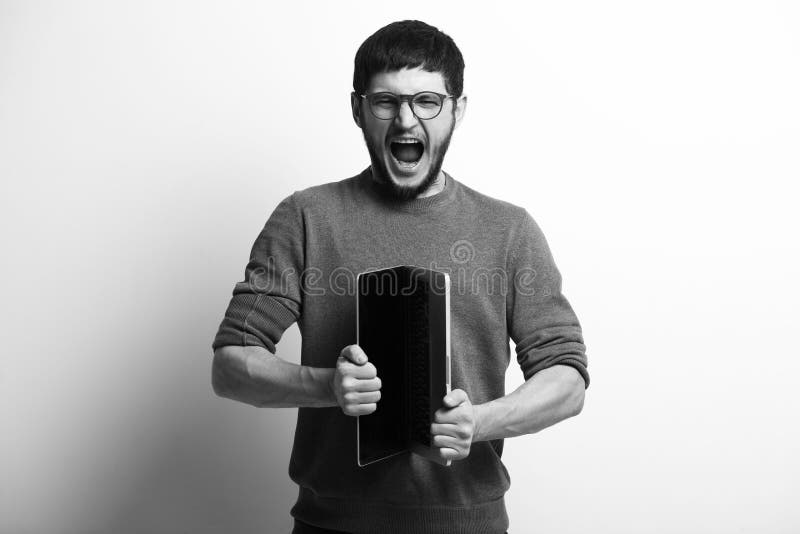 Black and white portrait of screaming young man opening laptop stock image Black and white portrait of screaming young man opening laptop stock image