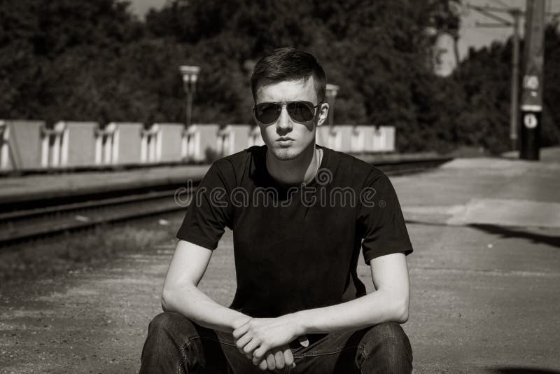 Black and White Portrait of Serious Handsome Young Man Sitting on a ...