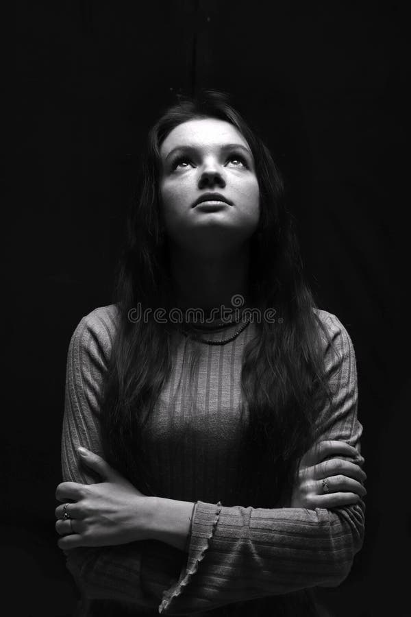 Black and white portrait of a young girl looking up girl with long hair.  Woman prying