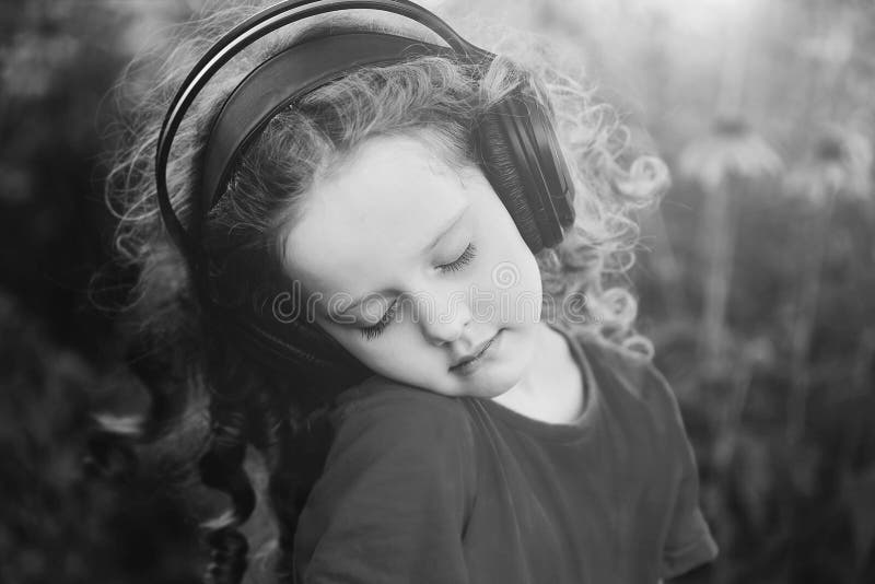 Black and white pottrait a little girl listening to music stock photos Black and white pottrait a little girl listening to music stock photos