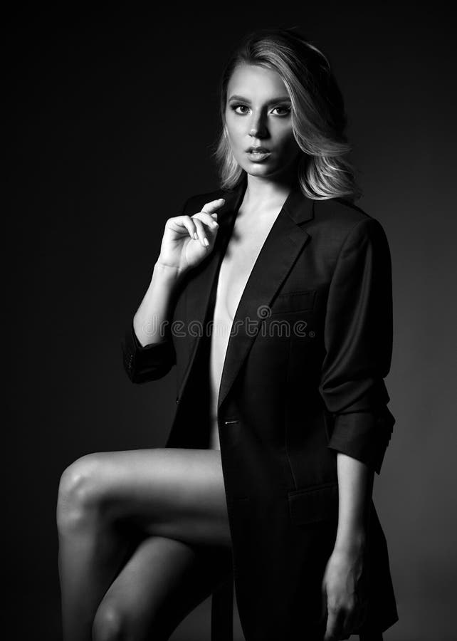 Sensual Young Blonde Woman is Sitting on the Chair in Official Jacket Over  Her Naked Body Holding Her Hand at Her Breast Stock Photo - Image of  independent, fashion: 159014942