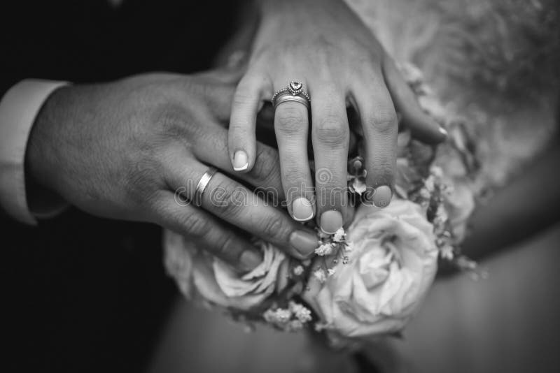 Black And White Shot Of The Hands Of A Bride And Groom Showing Their Rings Wedding