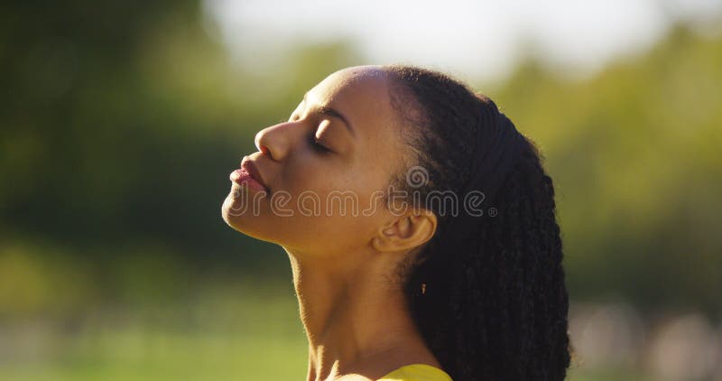 Black woman feeling the sun shine on her face