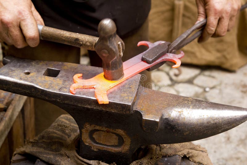 Herrero falsificado hierro herrero yunque tradicional martillo golpeando.