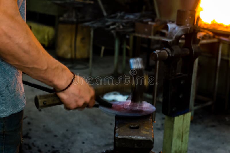 The Blacksmith Manually the Molten Metal on the Anvil Stock