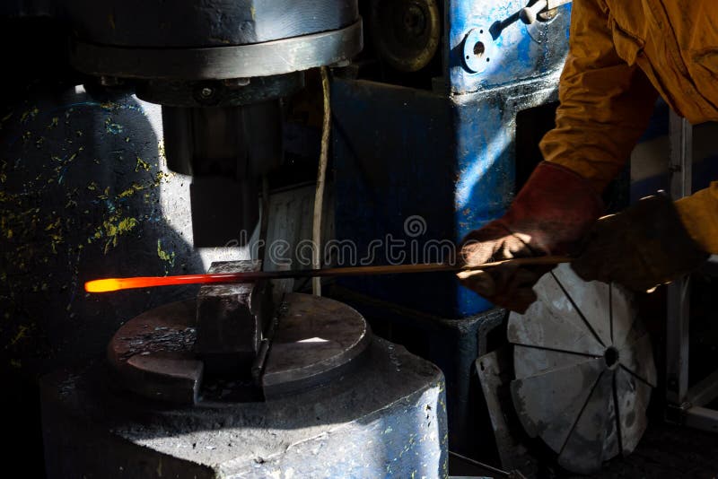 The Blacksmith Manually the Molten Metal on the Anvil Stock