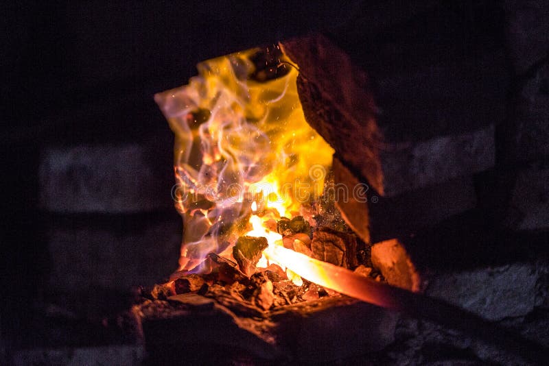 In a blacksmith`s workshop. The metal billet is held in a coal flame in a furnace. An example of the hard work of ancient crafts royalty free stock photography