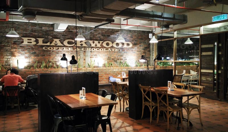Inside a coffee house. The counter or serving area and seating for customers.