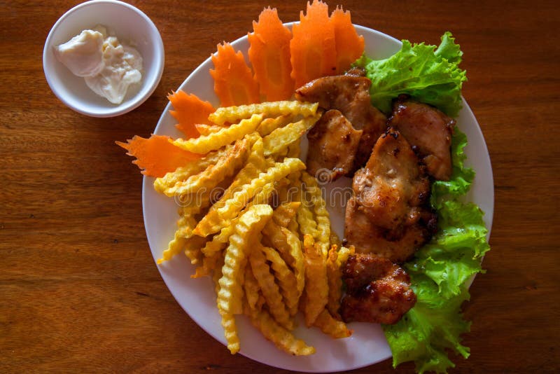 Blanc de poulet avec les pommes frites et la salade du plat blanc Photo de vue supérieure de poulet frit sur la table en bois photographie stock libre de droits Blanc de poulet avec les pommes frites et la salade du plat blanc Photo de vue supérieure de poulet frit sur la table en bois photographie stock libre de droits