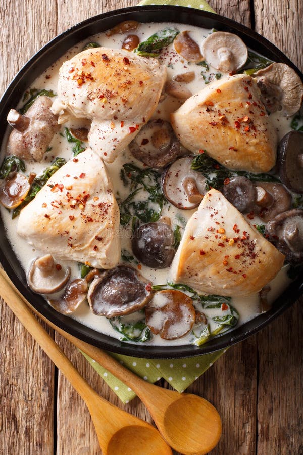 Blanc de poulet cuit avec la sauce aux champignons et les épinards sauvage étroits photographie stock libre de droits Blanc de poulet cuit avec la sauce aux champignons et les épinards sauvage étroits photographie stock libre de droits