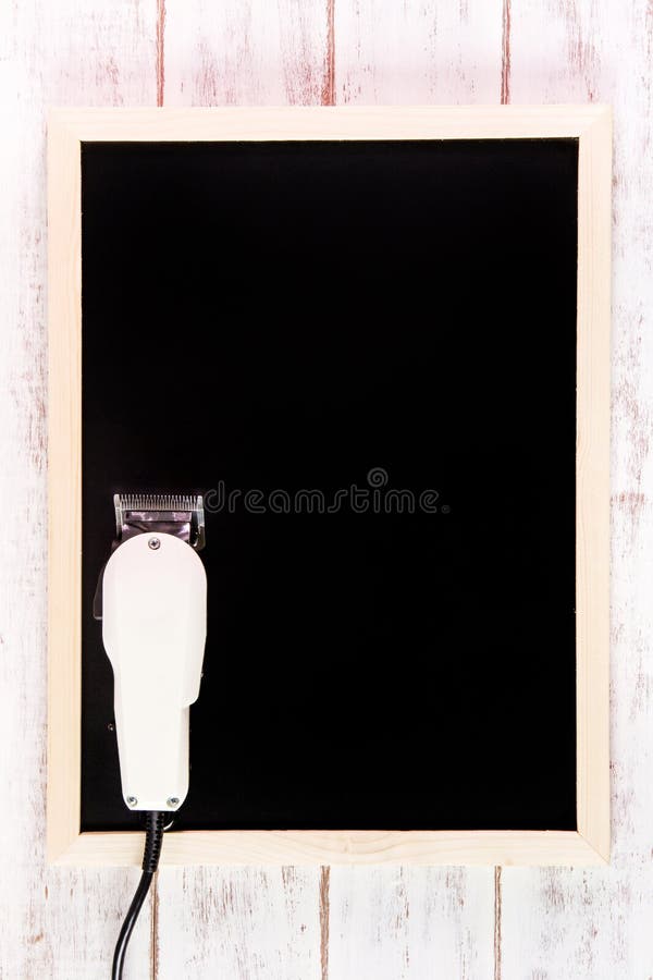 Blank blackboard and Clipper Barber on wooden table. Template mock up for adding your design and leave space beside frame for royalty free stock images