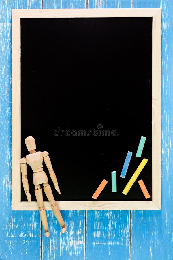 Blank blackboard, Color chalk and Wooden puppe on wooden table. stock photo